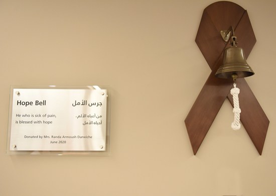 The Hope Bell plaque and bell mounted on a wooden ribbon at AUBMC.
